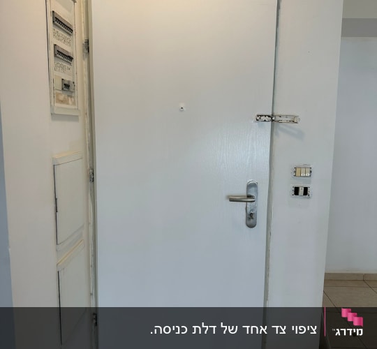 דלת לבנה עם ידית מתכת ומנעול